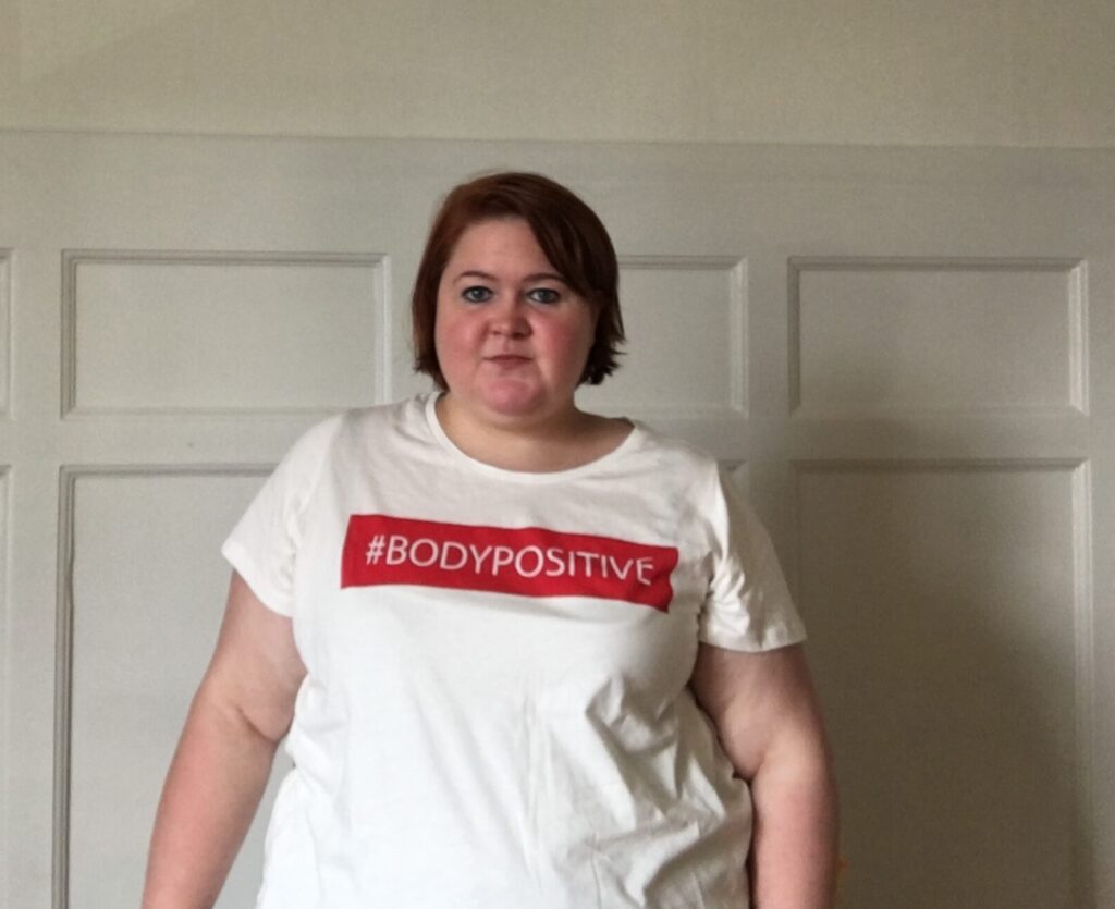 Billede af plus size kvinde i t-shirt med teksten #Bodypositive på.